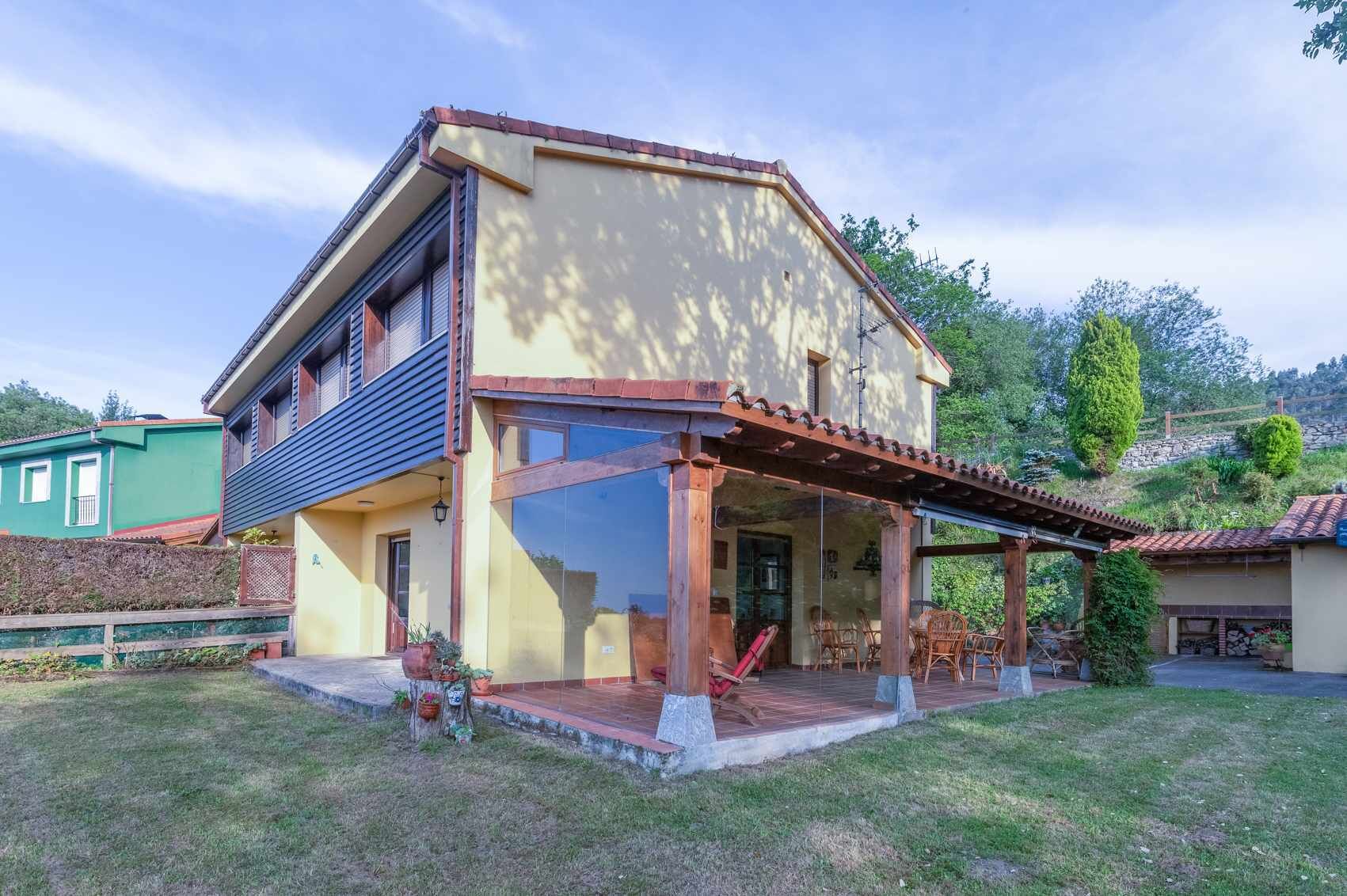 A two-story house with a large glass door and a covered patio area.