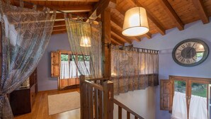 A wooden interior with a staircase, a large clock, and patterned curtains. - Villa Las Ardillas con Piscina (Cardoso (Llanes))