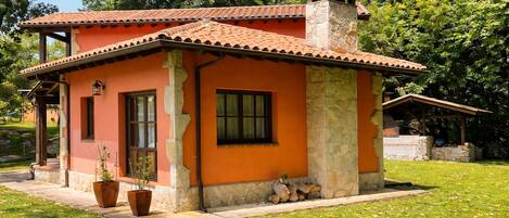 Una casa petita d'una sola planta amb teulada de rajola vermella i parets de pedra.