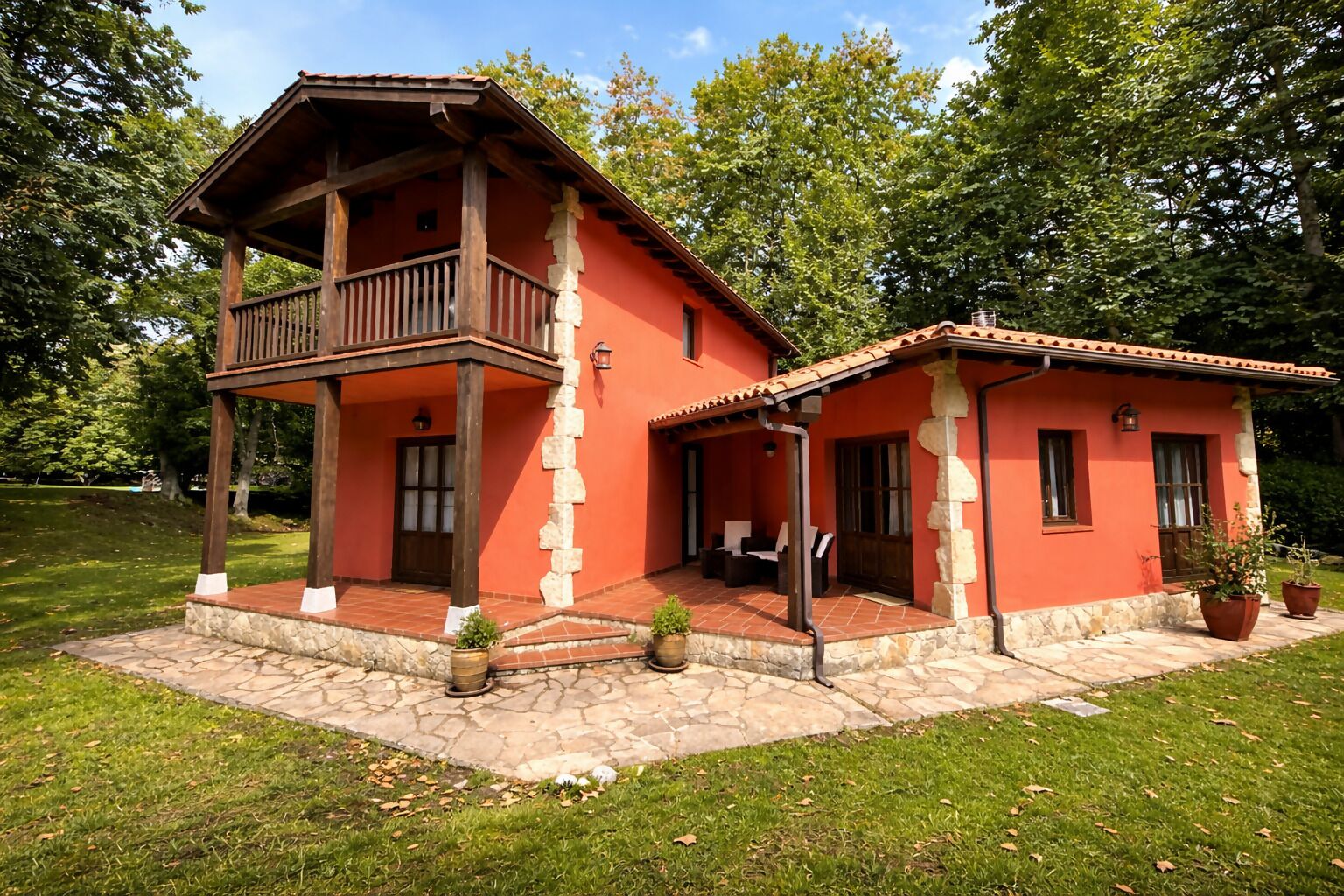 A two-story house with a balcony and a patio area.