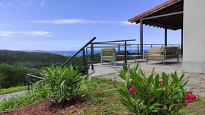 Une terrasse avec des sièges extérieurs et une vue sur le paysage.