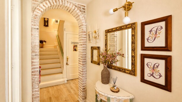 A hallway with a staircase, a vanity with a mirror, and framed artwork on the wall. - Casa La Venta de Pedro (Ribadesella)