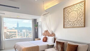 A modern hotel room with a large bed, a sofa, a round coffee table, and a city view. - Urban Abode Apartment 1 (Taipei)