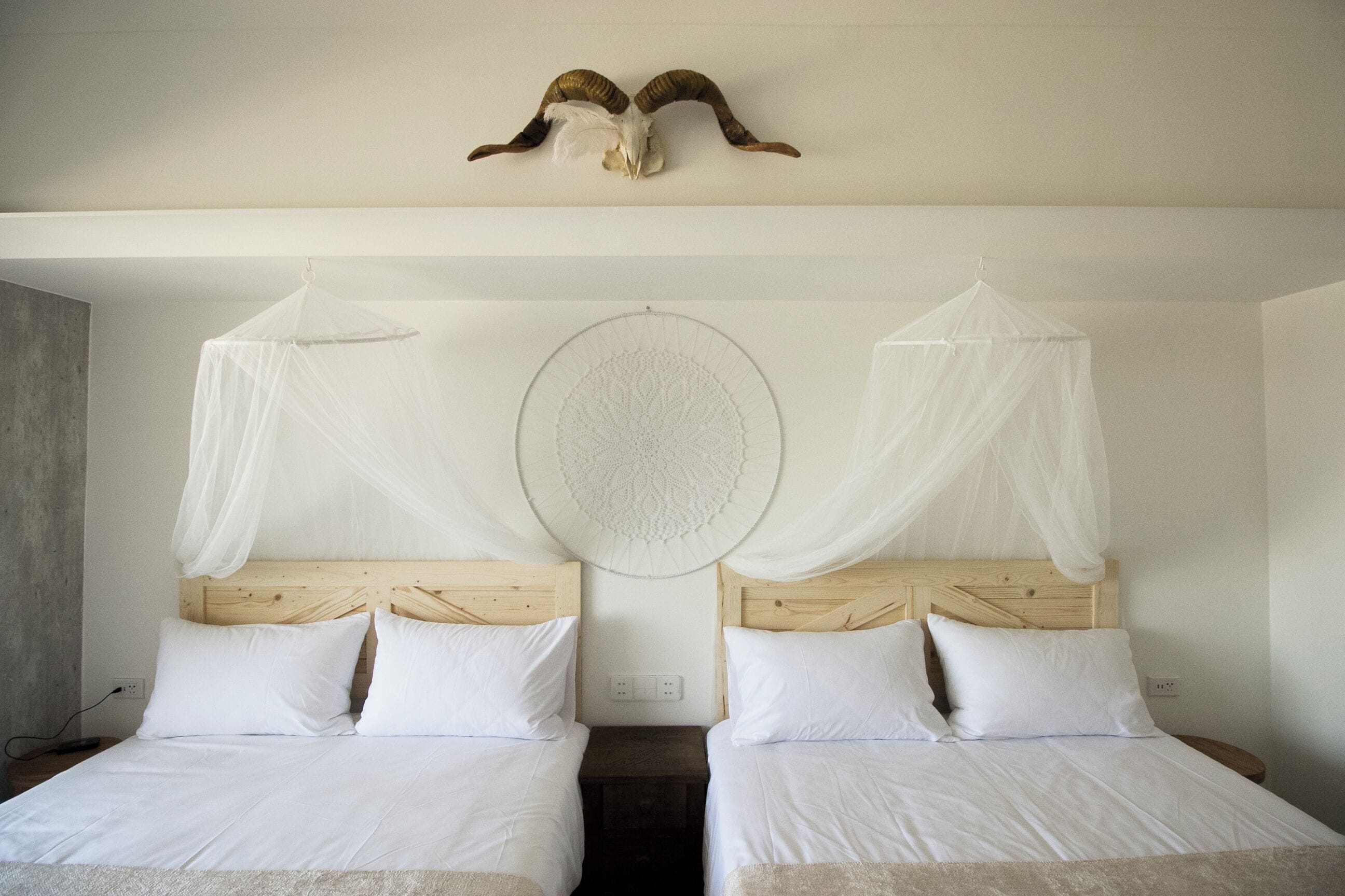 Una cama doble con cabecera de madera, ropa de cama blanca y un adorno decorativo en la pared.