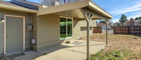 A modern house with a covered patio, a garage, and a fenced backyard.