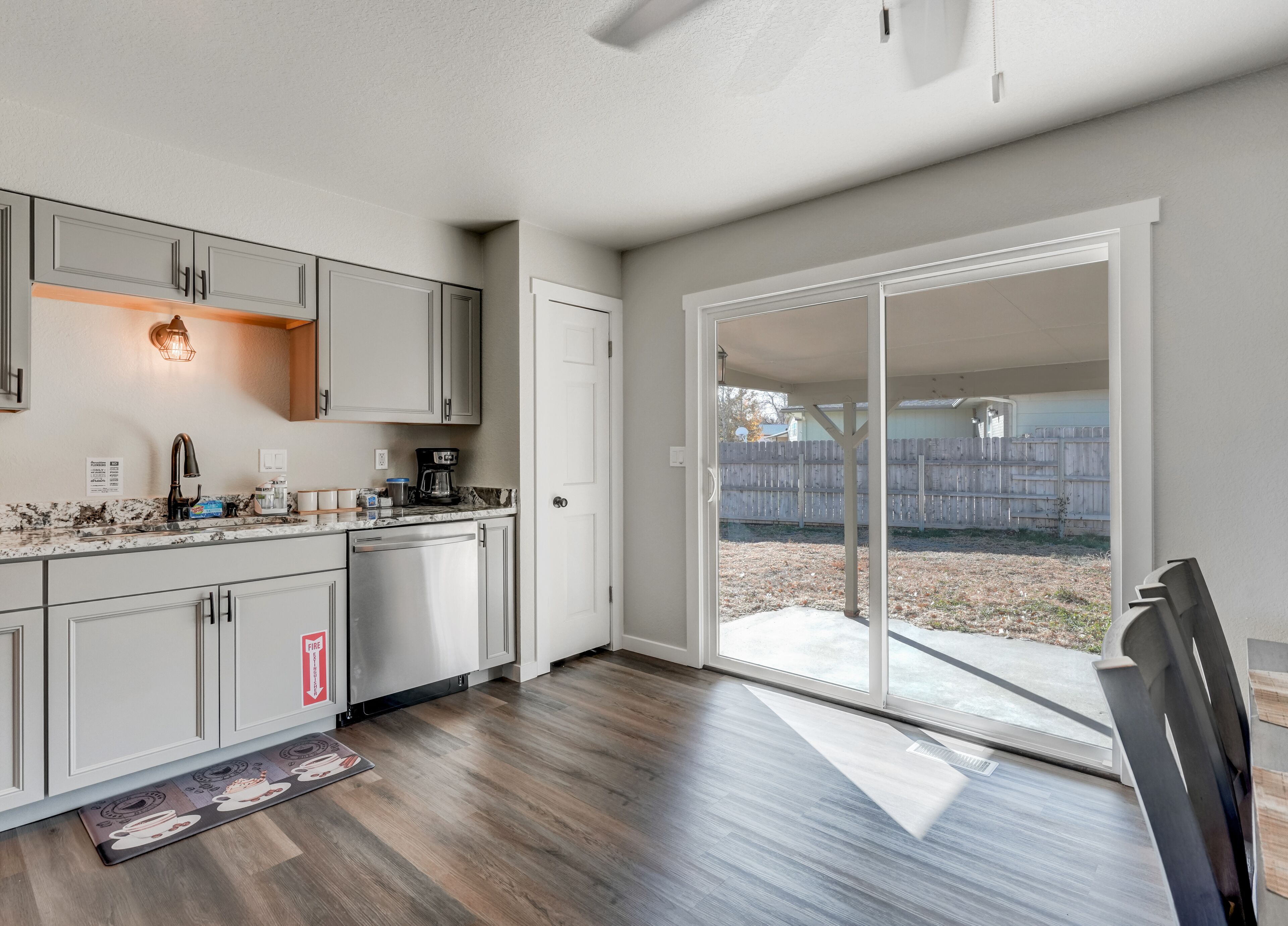 A kitchen with a built-in oven, a coffee maker, and a sink.