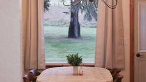 A dining table with a floral tablecloth, a potted plant, and a vase. - The Highland View House (Somerset)