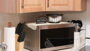A kitchen with a microwave, a sign reading "Bed & Breakfast You Make Both," and a basket of white napkins. - The Highland View House (Somerset)
