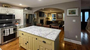 A modern kitchen with white cabinets, stainless steel appliances, and a marble island. - Charming Farmhouse In Quarryville,PA

 (Quarryville)