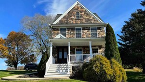 A two-story stone house with a front porch and a small staircase leading to the entrance. - Charming Farmhouse In Quarryville,PA

 (Quarryville)