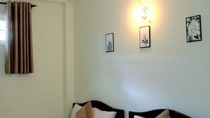 A hotel room with two single beds, a window with curtains, and wall-mounted light fixtures. - Kamy Phuong House and Spa (Xuan Huong - Da Lat)