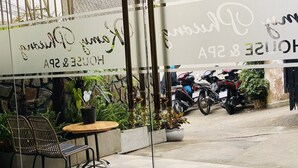 A hotel entrance with a sign reading "Hotel & SPA". There are potted plants and a seating area with chairs and a table. Motorcycles are parked outside. - Kamy Phuong House and Spa (Xuan Huong - Da Lat)