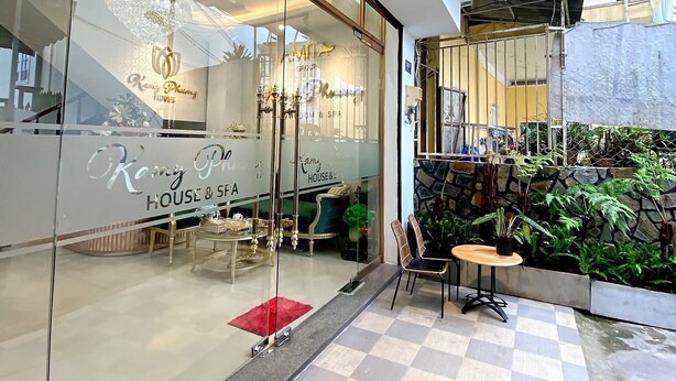 A modern hotel interior with a glass facade, elegant chandeliers, and a checkered floor. - Kamy Phuong House and Spa (Xuan Huong - Da Lat)