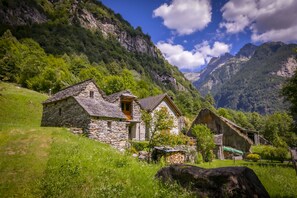 Traditional stone houses blend seamlessly into the lush green surroundings of this mountain village.