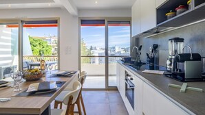 A modern kitchen with a large island, built-in appliances, and a view of the city.