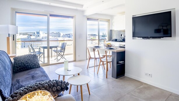 A modern apartment with a balcony, a dining area, and a kitchen.