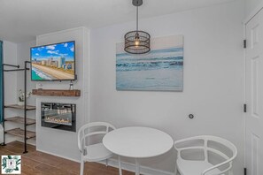 A modern living room with a TV, artwork, and a fireplace. - Direct Oceanfront Two Bedroom Condo (Myrtle Beach)