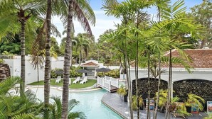 A pool surrounded by palm trees and a white fence. - Alassio 1 Bedroom Pool View Apartment 204/1 (Cairns)
