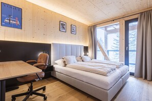 Ein modernes Schlafzimmer mit einem großen Bett, einem Schreibtisch und einem Sessel.
