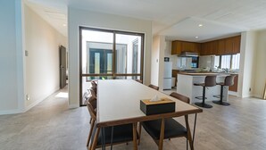 Una cocina moderna con armarios de madera, una isla central y taburetes de bar.