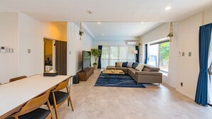 Una sala de estar moderna con un sofá, una mesa de centro y un comedor con sillas y una mesa.