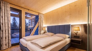 Une chambre à coucher avec un lit, deux tables de chevet et une fenêtre avec des rideaux.