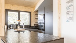 Eine moderne Küche mit Granit-Arbeitsplatten, Edelstahlgeräten und Holzschränken.