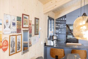 Una cocina con paredes de madera, una zona de bar y varias fotos y carteles enmarcados.