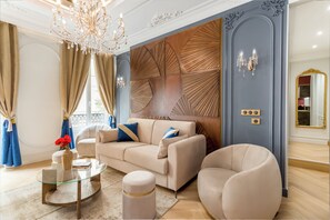 Relax in style with a plush sofa, round armchair, and glass coffee table in this elegant living room.