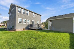 A two-story residential house with a front deck and a garage.