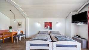 Une chambre à coucher avec un lit, une télévision, un bureau et une chaise.
