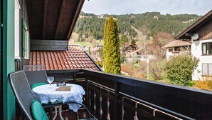 A balcony with a table, chairs, and a view of a mountainous landscape. - Studio Apartment 'Appartement  Braun 3' with Mountain View, Balcony and Wi-Fi (Bolsterlang)