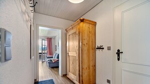 Ein Flur mit einem Holzschrank, einer weißen Tür und einer blauen Matte.