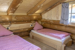 A cabin with two wooden beds, a window with a curtain, and a wall-mounted power outlet. - Holiday Home 'Hofblick' with Private Terrace, Private Garden and Wi-Fi (Glatten)