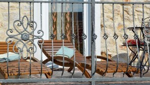 A balcony with wooden furniture and a bicycle.