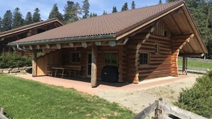 A log cabin with a covered patio, outdoor seating, and a grill area. - Holiday Home 'Blockhaus Almhütte Wiesenglück' with Private Terrace, Private Garden and Wi-Fi (Glatten)