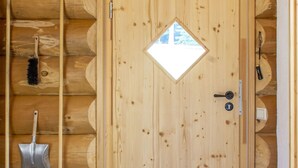 A wooden cabin interior with a door, a window, and a broom hanging on the wall. - Holiday Home 'Blockhaus Almhütte Wiesenglück' with Private Terrace, Private Garden and Wi-Fi (Glatten)
