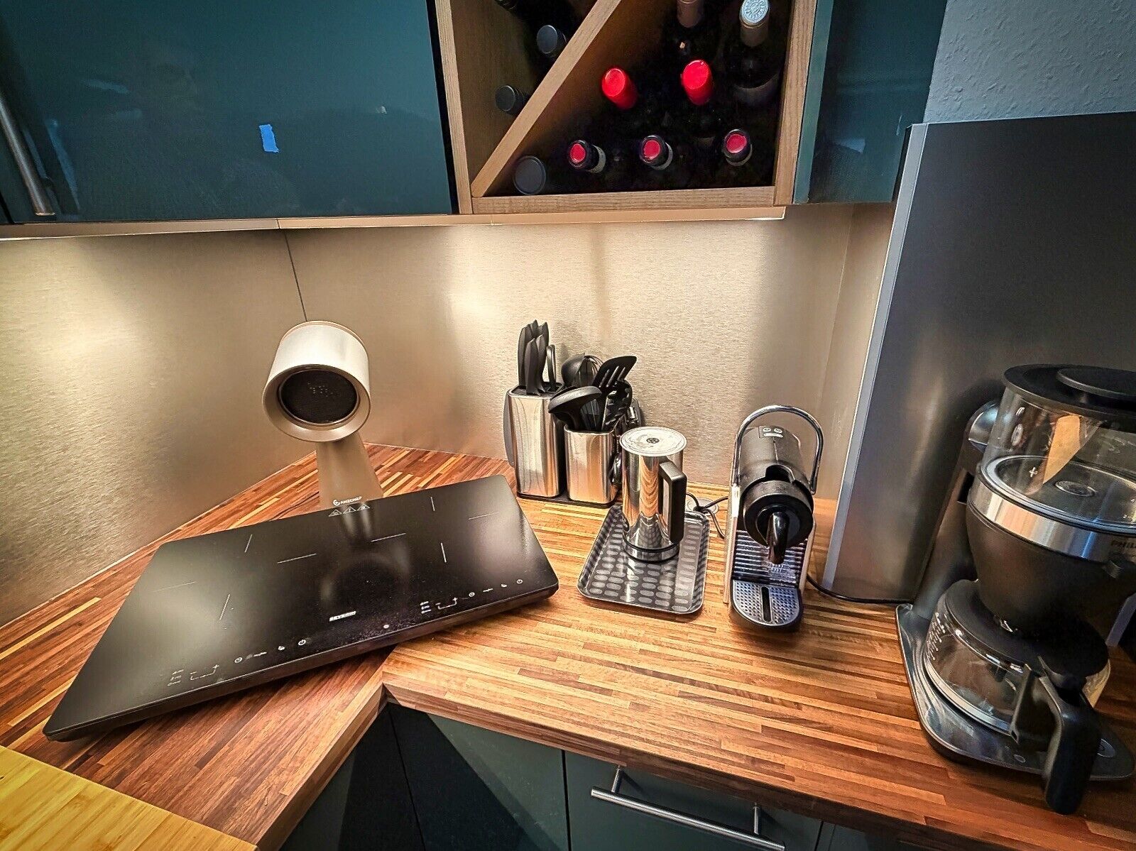 Un plan de travail de cuisine avec une machine à café, une bouilloire et un mixeur.
