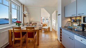 Una cocina moderna con encimera de granito, armarios blancos y horno empotrado.