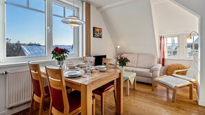 Un comedor con una mesa de madera, sillas y vistas al exterior.
