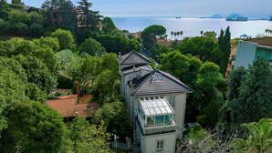 A coastal house with a prominent bay view, surrounded by lush greenery and a clear sky. - Villa Liberty Albisola 6 2 Emma Villas (Albisola Superiore)