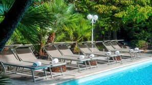 A poolside area with lounge chairs and a lamp post. - Villa Liberty Albisola 6 2 Emma Villas (Albisola Superiore)