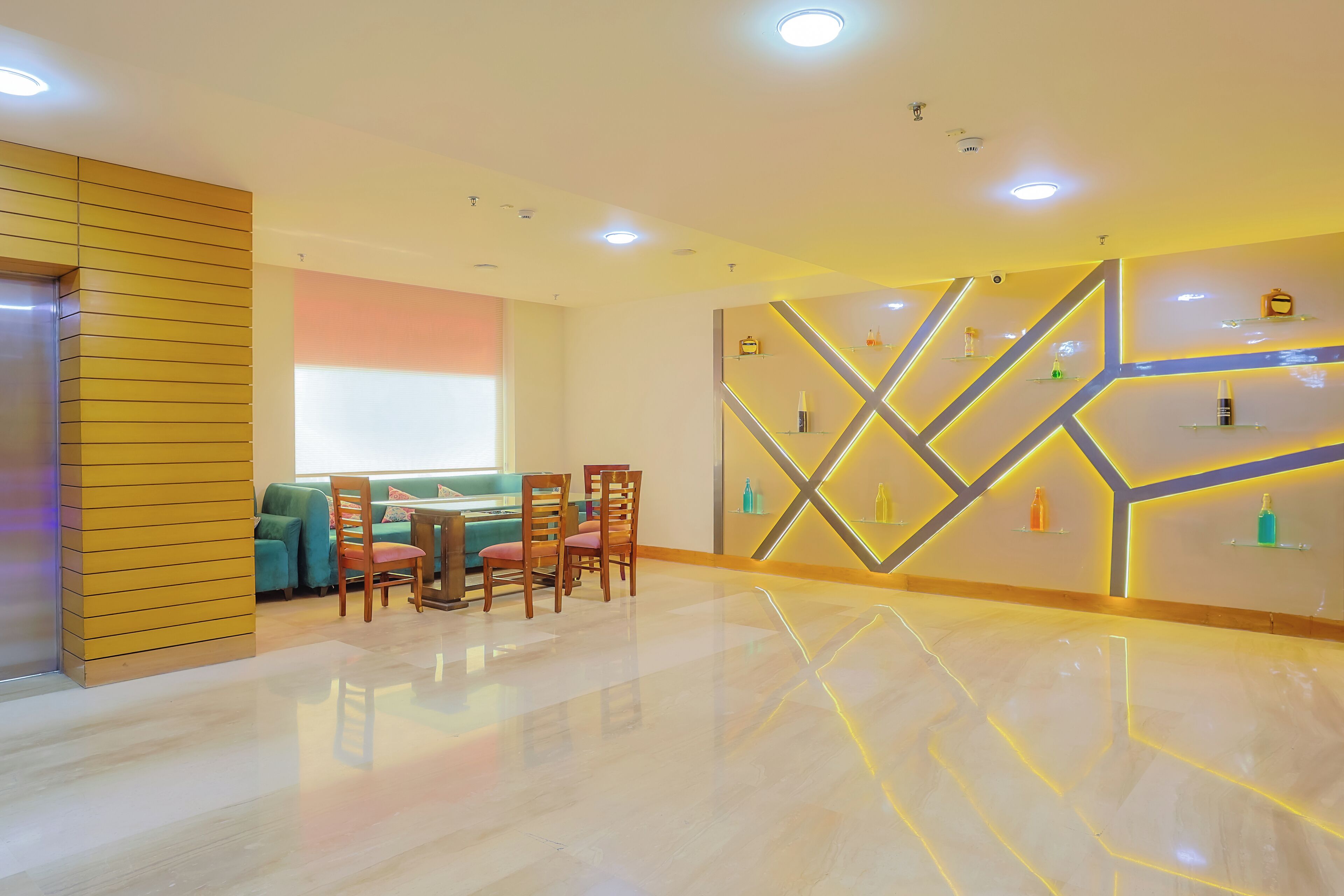 A modern interior with a dining area, a sofa, and a wall with geometric lighting.