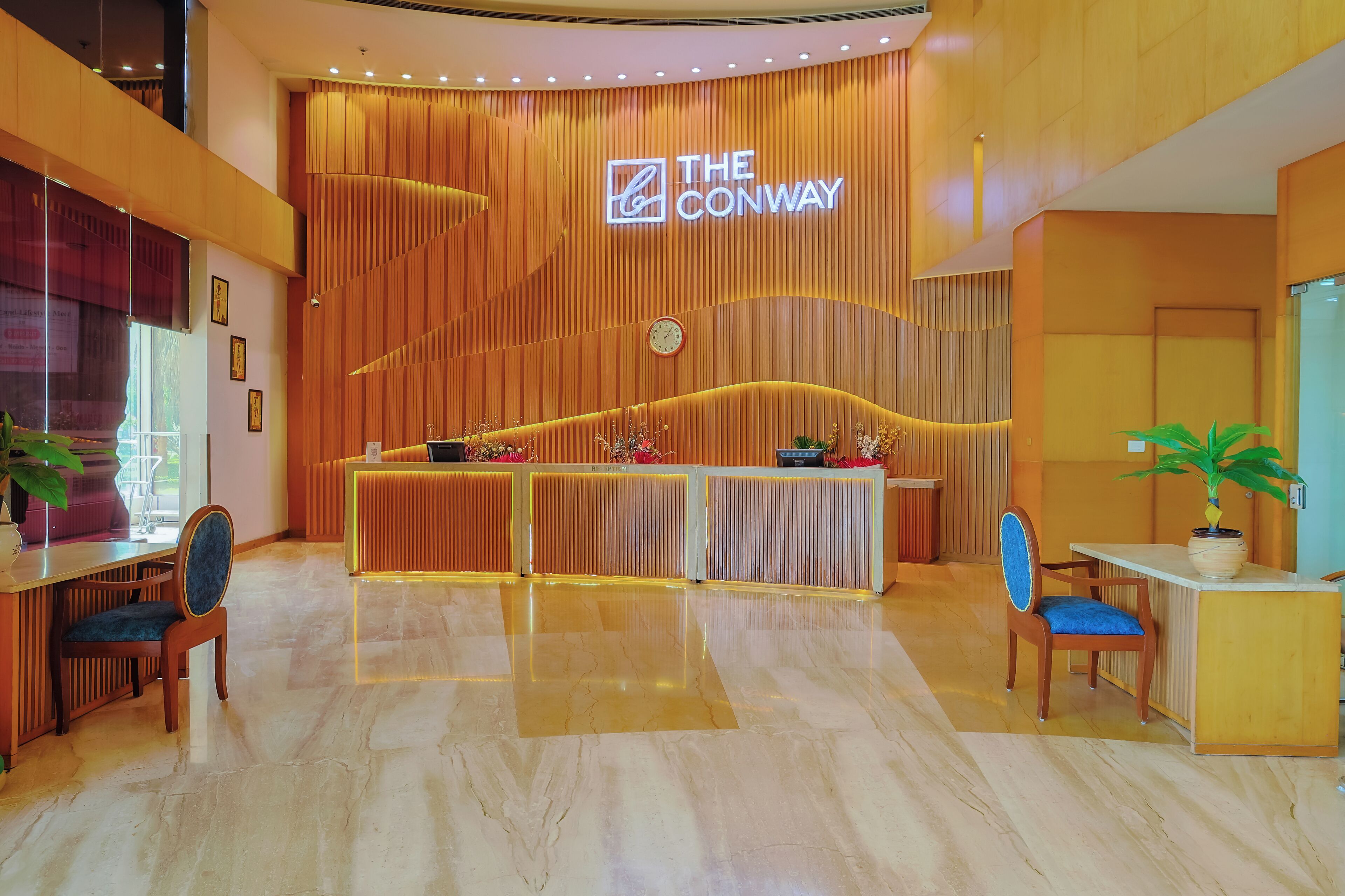 Un hall d’hôtel avec un comptoir d’accueil en bois, une horloge et une enseigne indiquant « The Conway ».