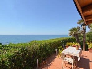 Un patio con mesa y sillas con vista al mar.