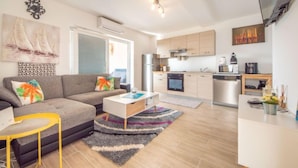 A modern living room with a sofa, coffee table, and a small dining area. - Steffano by Interhome (Karlobag)
