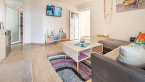 A modern living room with a grey sofa, a white coffee table, and a TV mounted on the wall. - Steffano by Interhome (Karlobag)