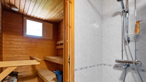 A wooden cabin with a shower area, wooden benches, and a small window. - Outapailakka j 12 by Interhome (Inari)