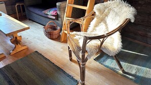 Een rustieke kamer met een houten stoel, een geweven mand, een houten tafel en een bank.