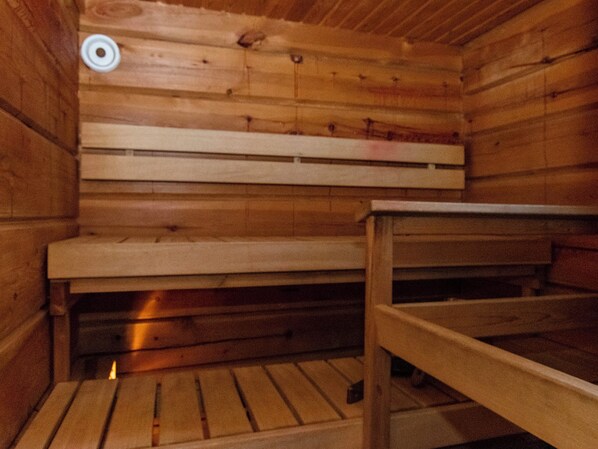 A wooden sauna with benches and a bench table.